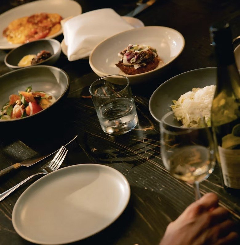A plated tasting menu on a dark table
